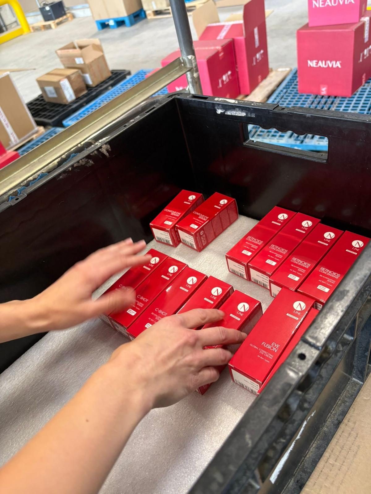 Kosmetikartikel werden von Hand in die Umverpackung gesetzt.