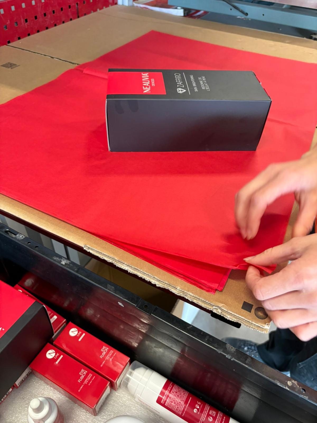 Konfektionierung einer Produktverpackung in Handarbeit.