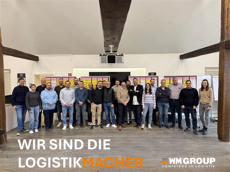 Das WM-GROUP-Team vor der Logo-Wand
